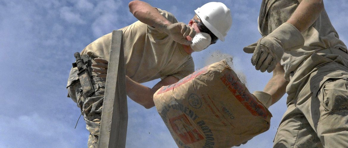 men tossing cement bags